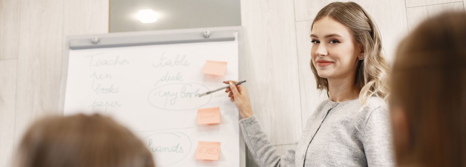 a female teacher at a whiteboard taking a class